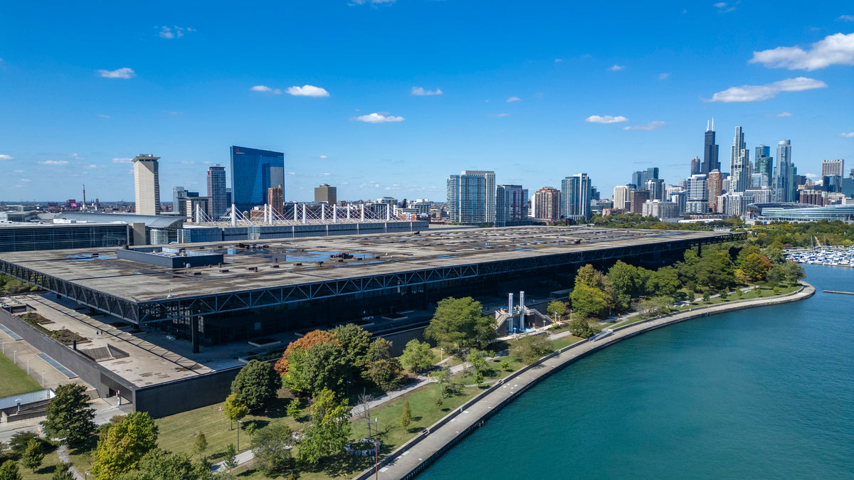 Large building near lake with city skyline at the back 