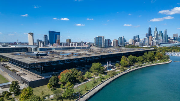 Large building near lake with city skyline at the back 